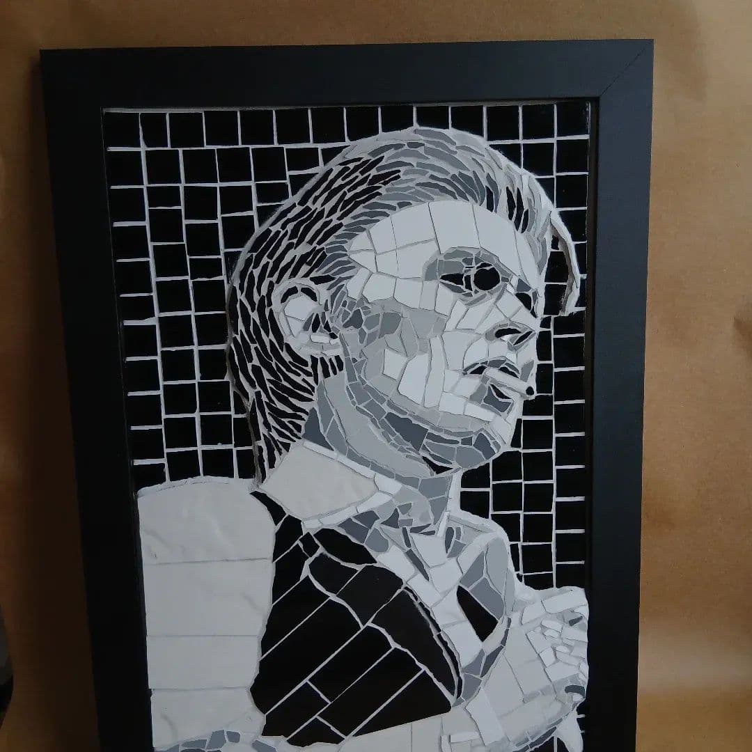 Retrato en mosaico en negro, blanco y gris del archivo aprobado del artista.